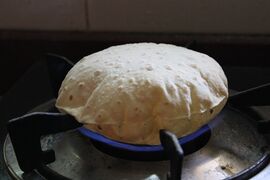 Chapatis are cooked on open-flame once it's partly cooked on tava, which fluffs it.